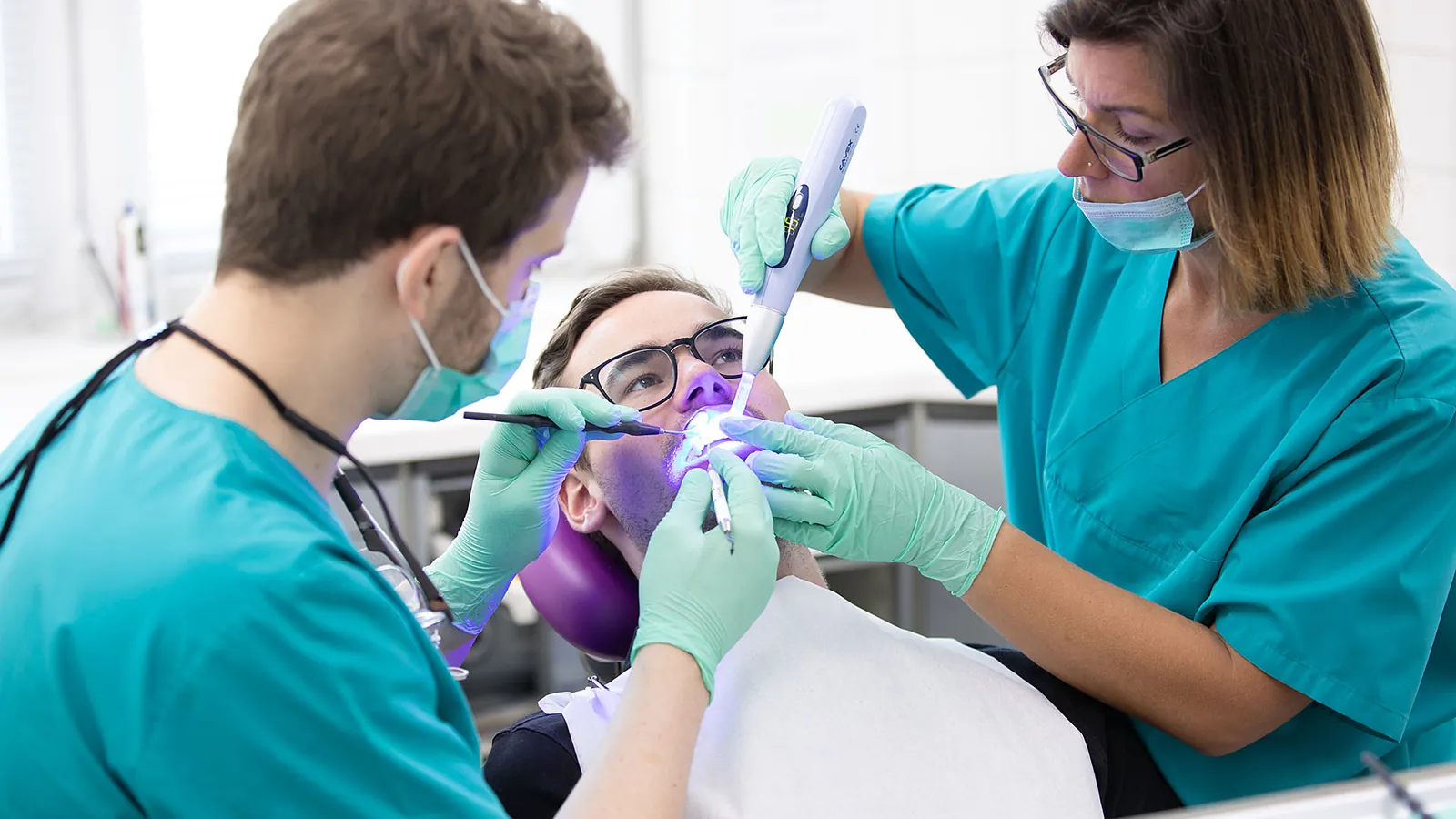 Behandlung bei Zahngesundheit Fuldatal: Behandler und Assistentin am Patienten